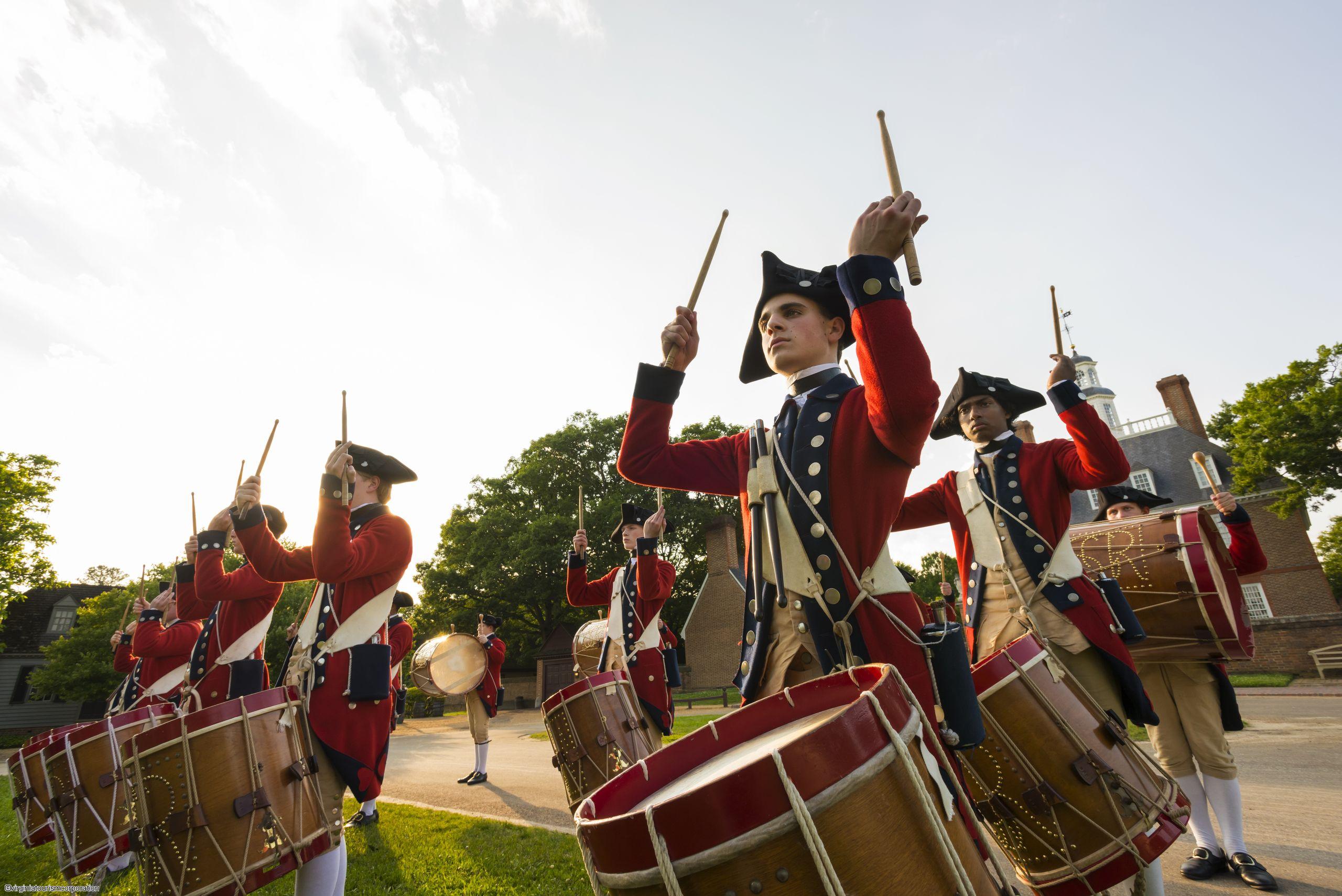 Défilé d'un orchestre en tenue militaire coloniale et qui joue du tambour dans les rues de Williamsburg